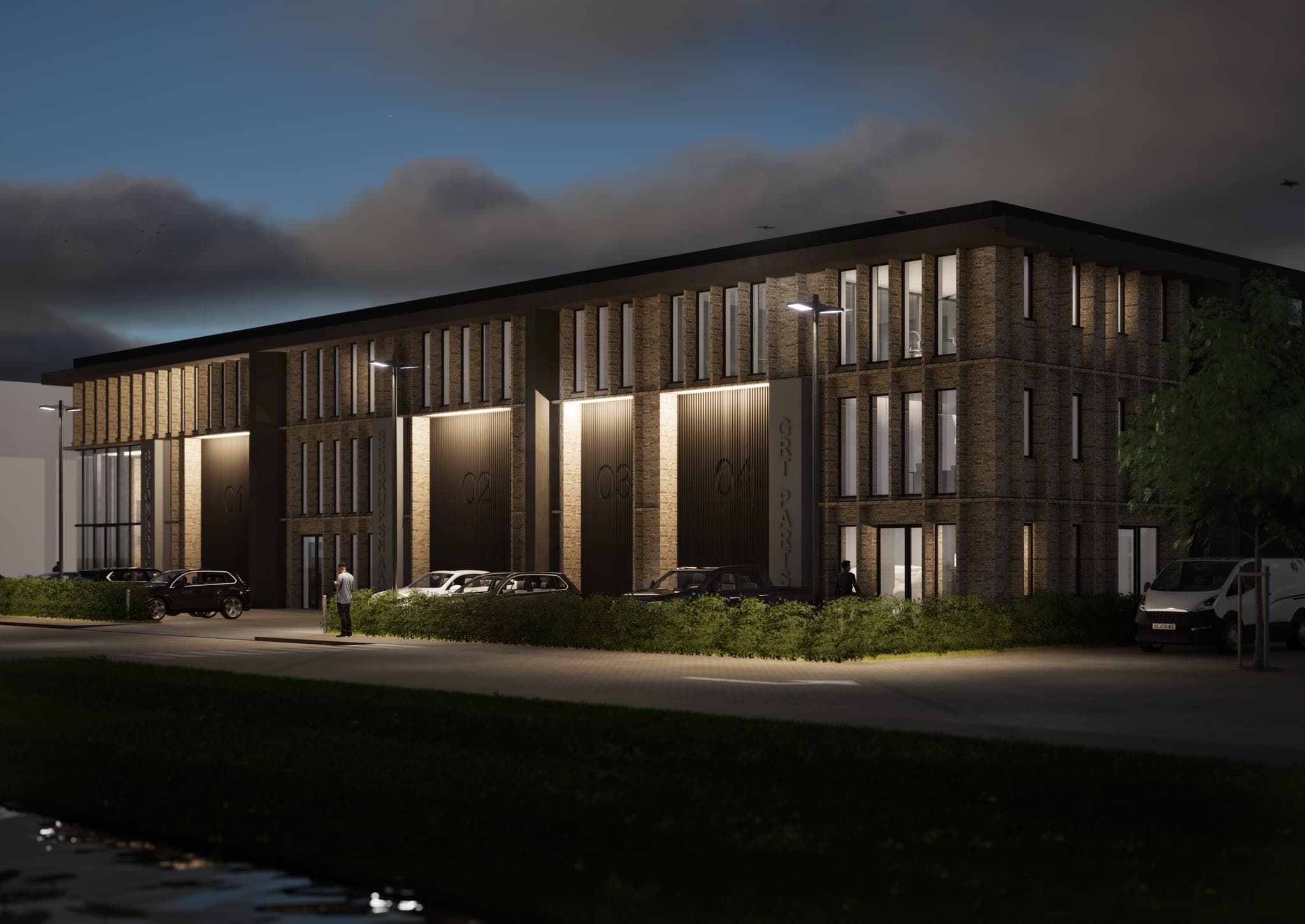 Het gebouw in de avond, met verlichte nissen boven de bedrijfsdeuren