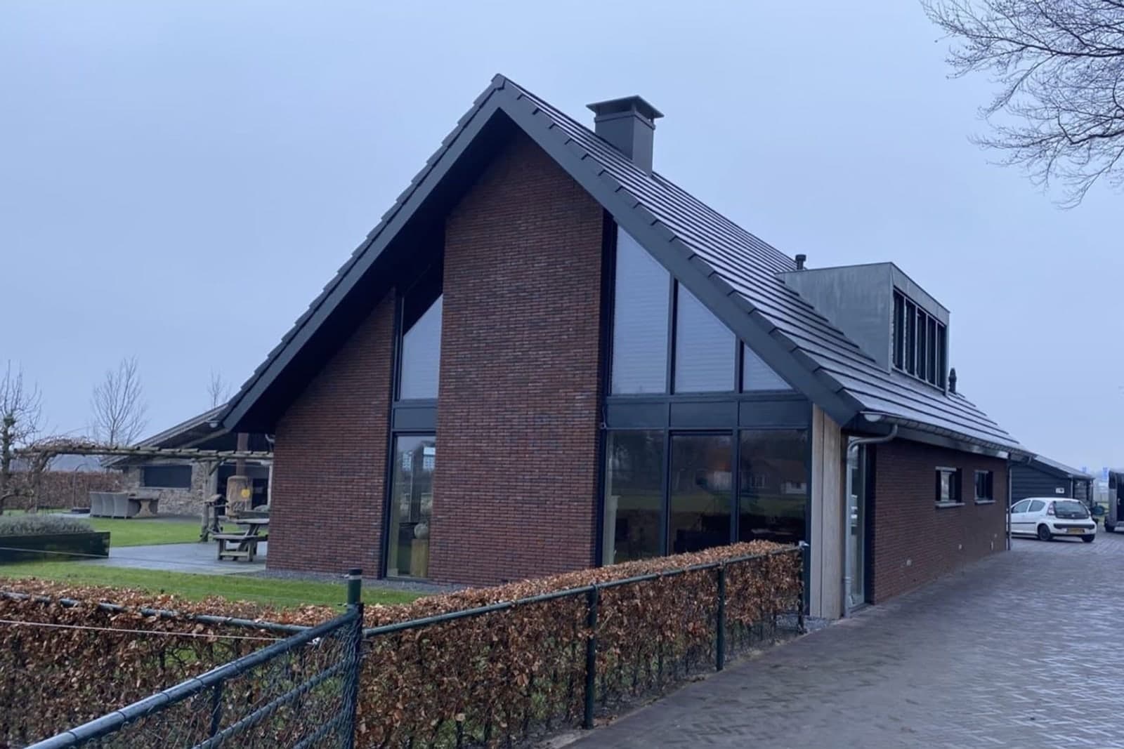 De woning vóór de metamorfose: rode baksteen en een donkere pannenkap
